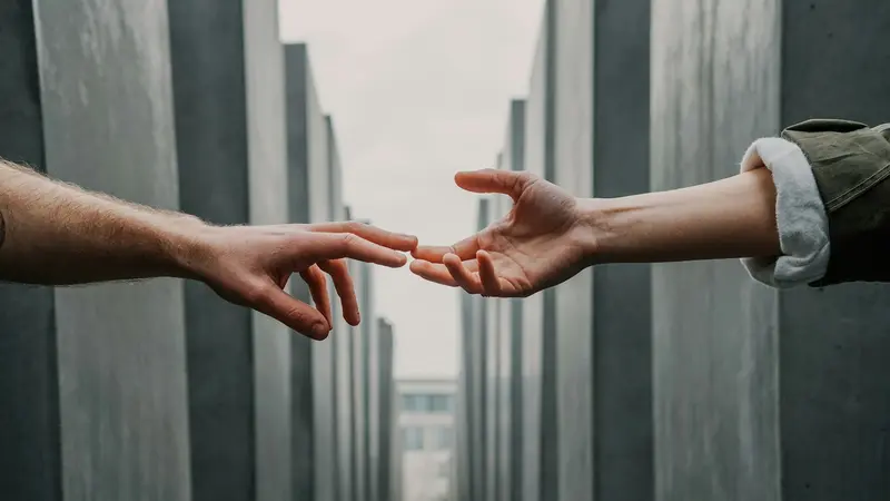 Two hands reaching toward each other in a gesture of support